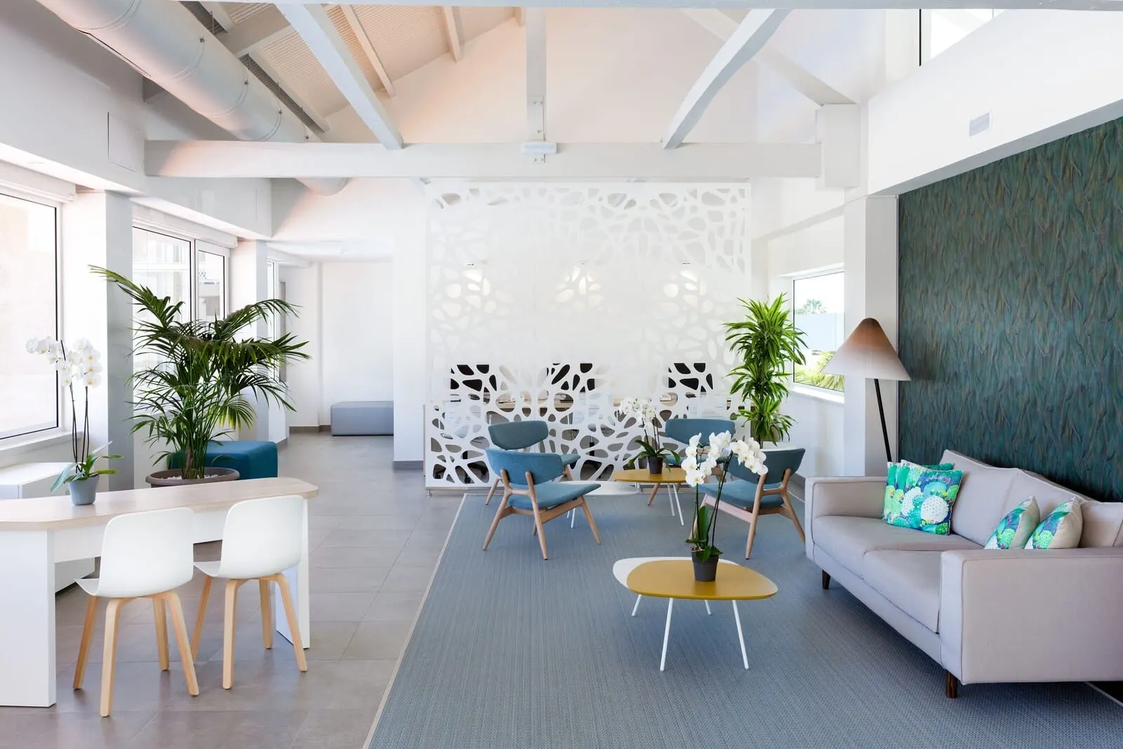 Hotel Tropical Park: A modern, well-lit office space with a white and grey color scheme, featuring a sofa