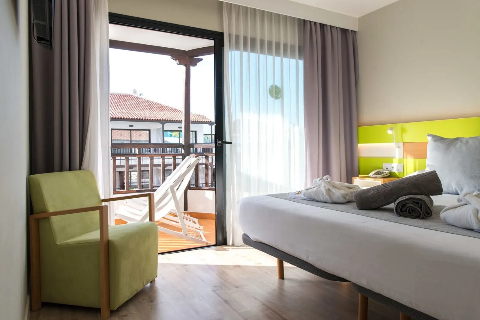 Vanilla Garden Boutique Hotel: A hotel room with a bed, a chair, a balcony with a railing