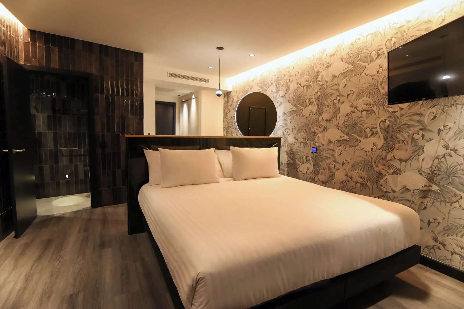 Silken Saaj Maar: A modern bedroom with a large bed, dark wood flooring, a wall-mounted TV
