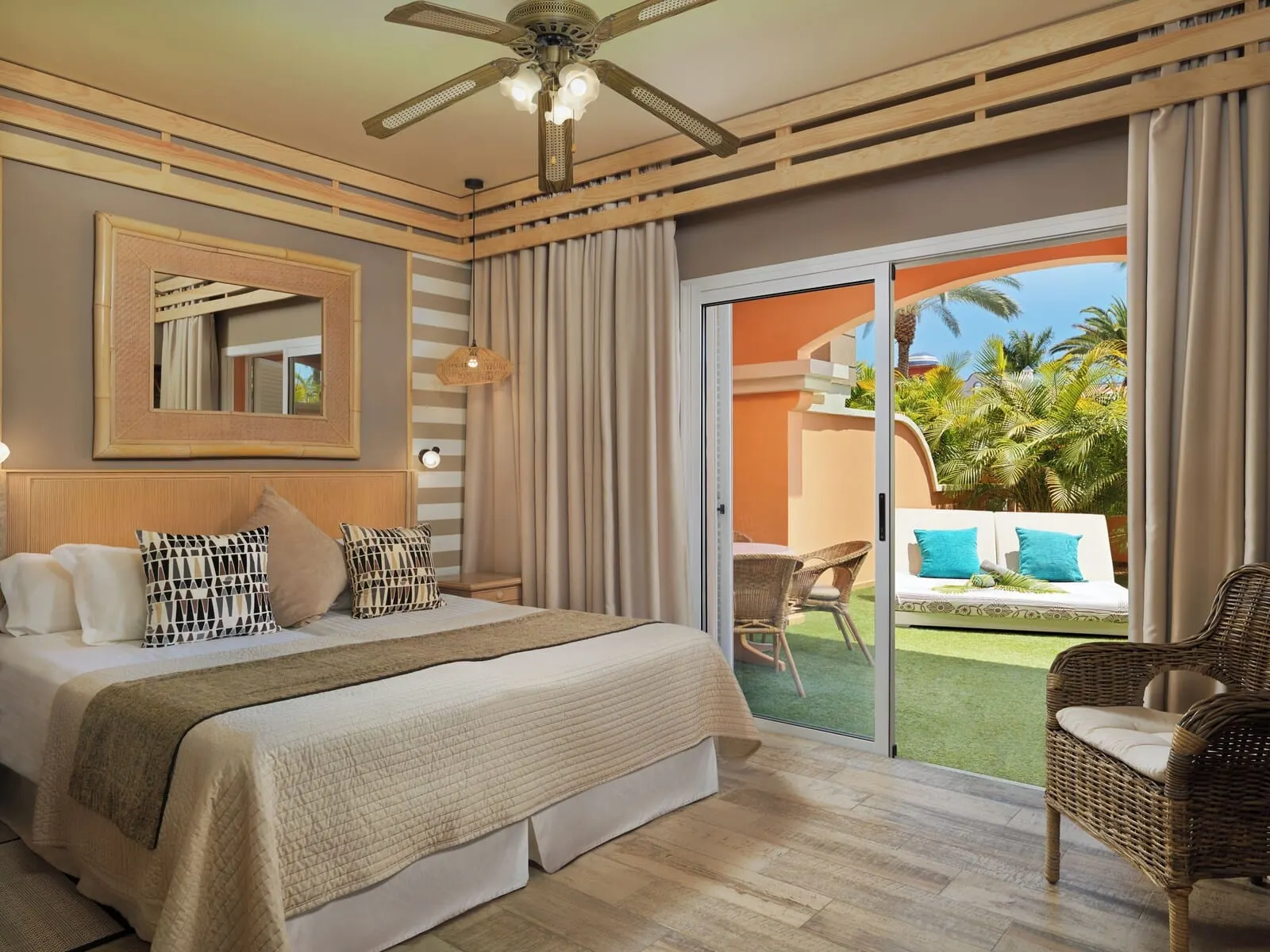 Green Garden Eco Resort & Villas: A hotel room with a large bed, a ceiling fan, a balcony with wicker furniture