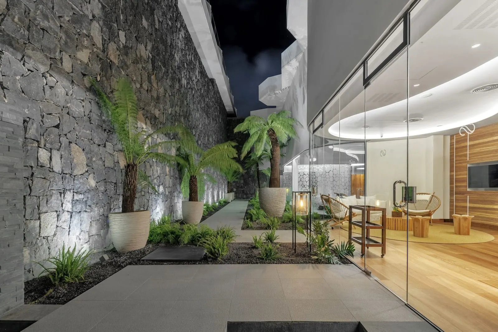 Royal Hideaway Corales Beach: A modern indoor space with a stone wall, potted plants