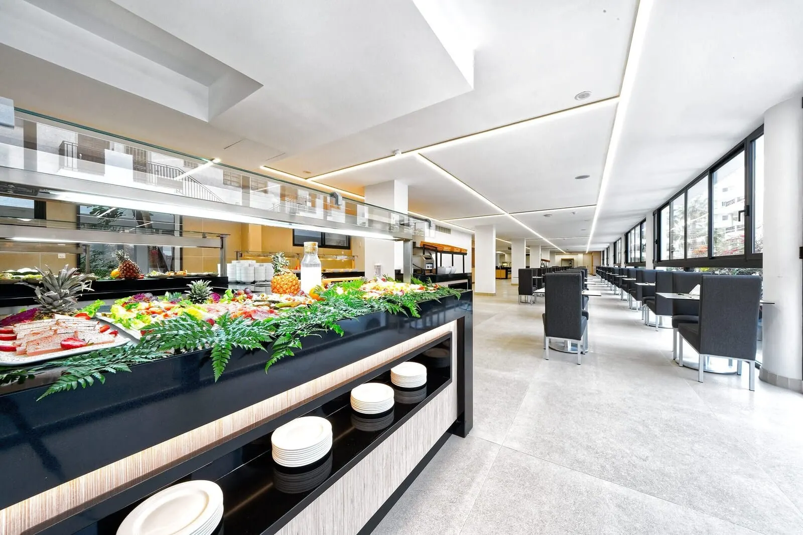 Hotel Parque La Paz: A modern hotel lobby with a buffet area featuring various food items and a seating area