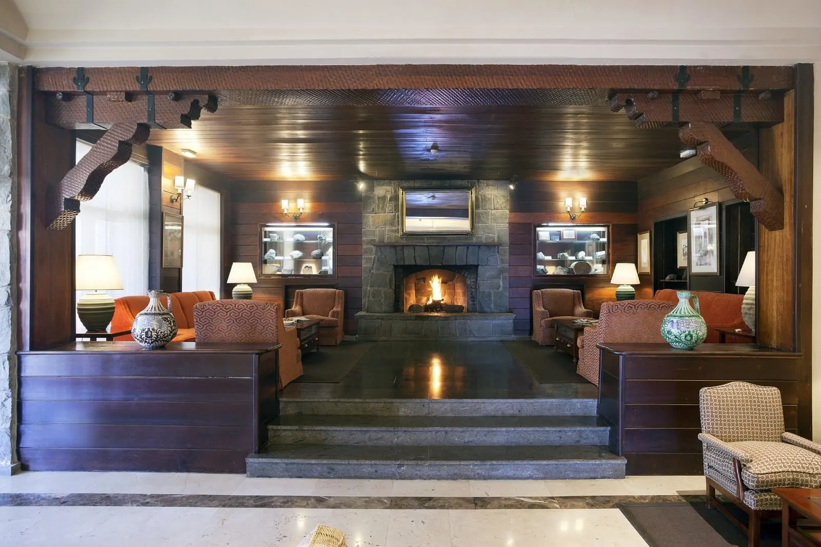 Parador de Las Cañadas del Teide: A lobby with a stone fireplace, wooden ceiling, and seating areas with lamps