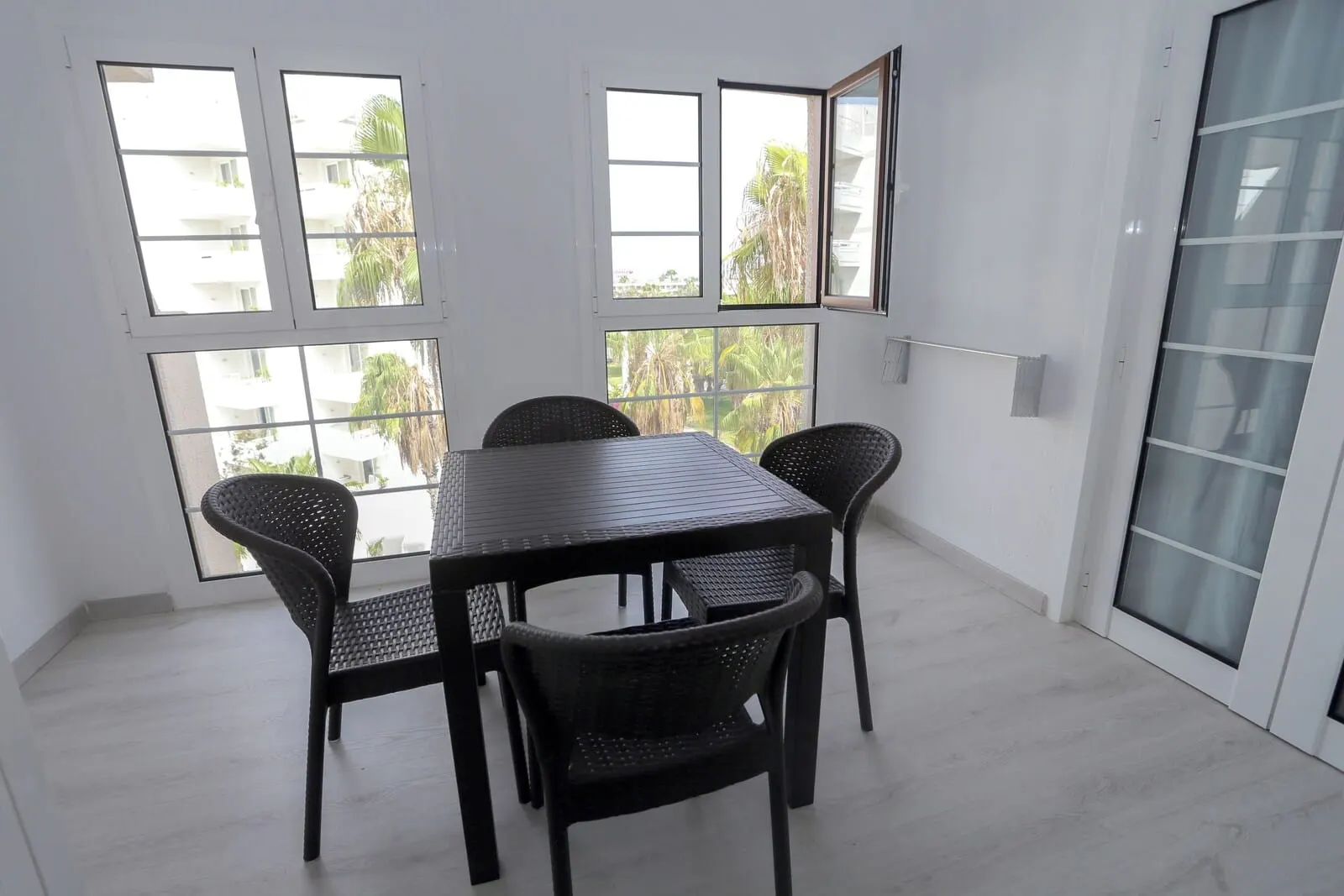 Hotel Andorra: A room with a dining table and chairs, large windows with a view of palm trees