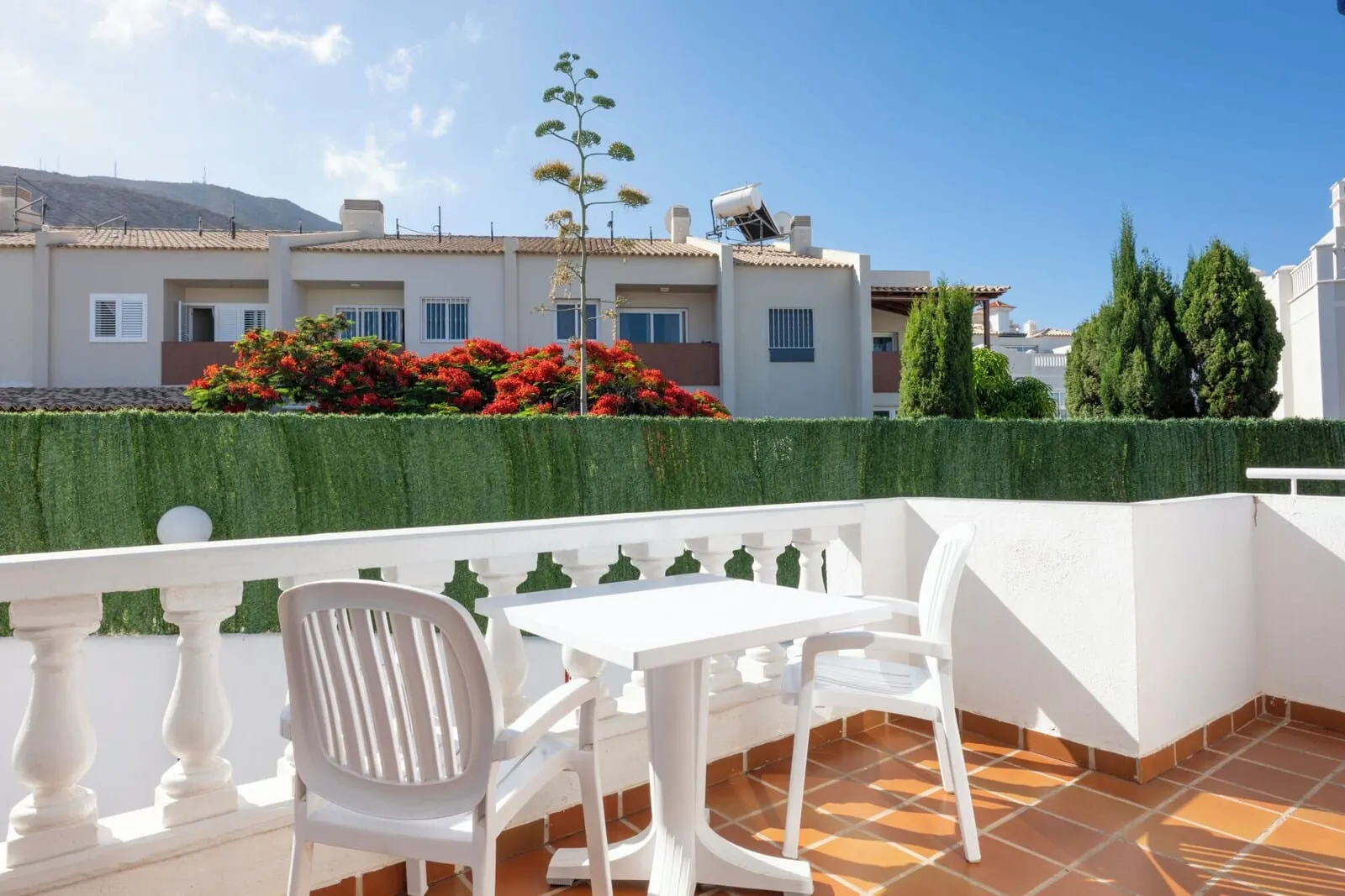 Ona Los Claveles: A terrace with white furniture, a white balustrade