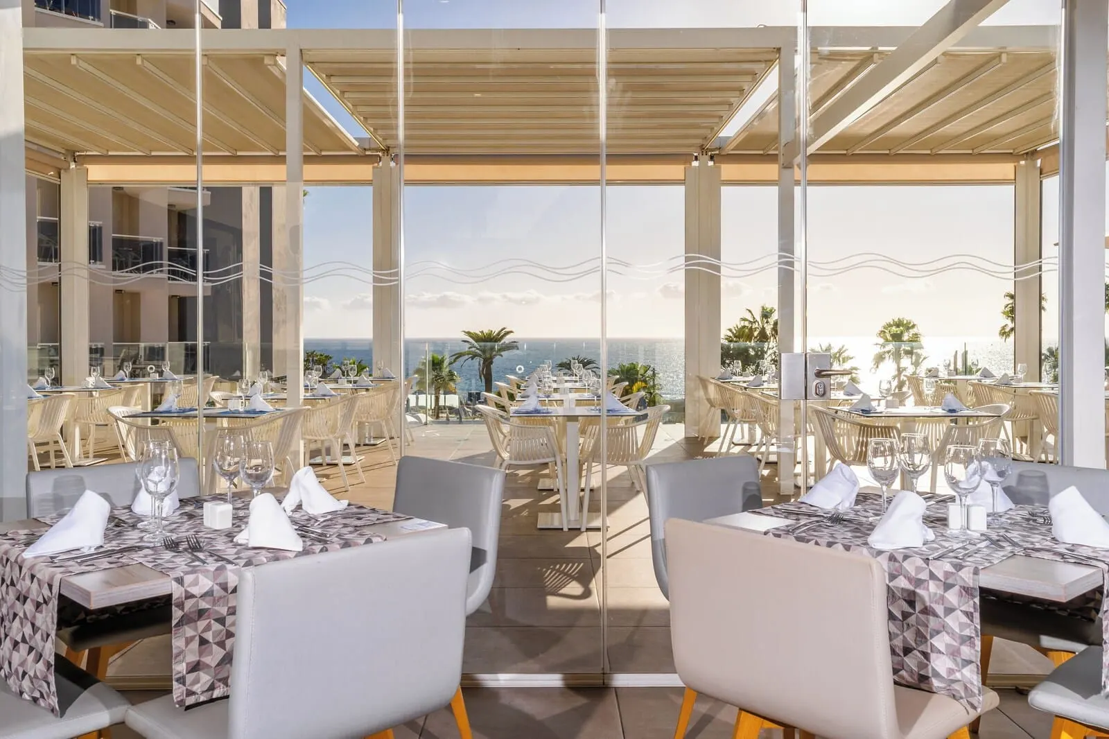 HOVIMA Cool Costa Adeje: An outdoor dining area with tables and chairs, overlooking a scenic view