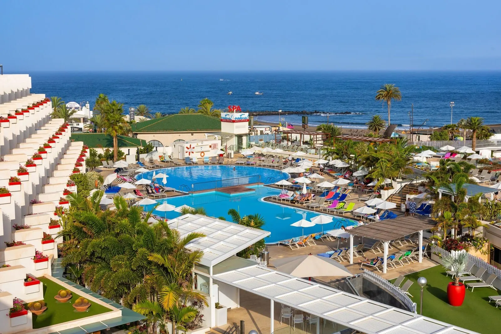Alexandre Gala: A resort with a large pool, sun loungers, and a view of the ocean