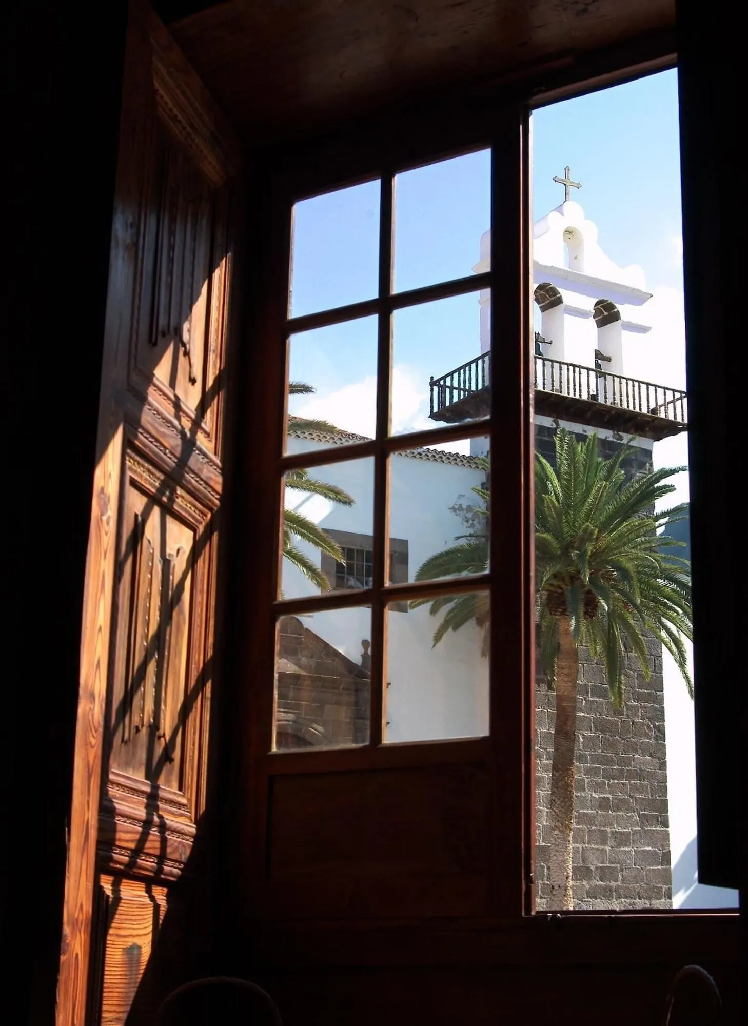 Hotel La Quinta Roja: A window with a view of a white building with a cross on top, a balcony