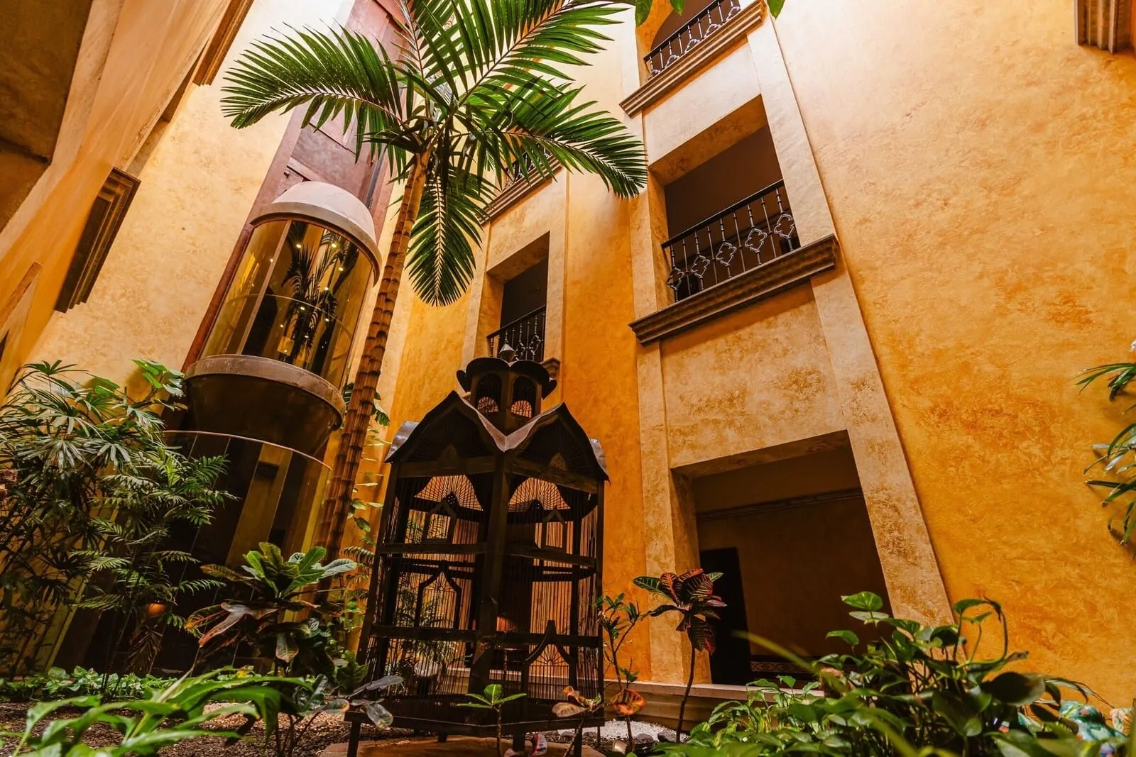 Europe Villa Cortés: A courtyard with a wooden gazebo, palm trees, and a building with balconies