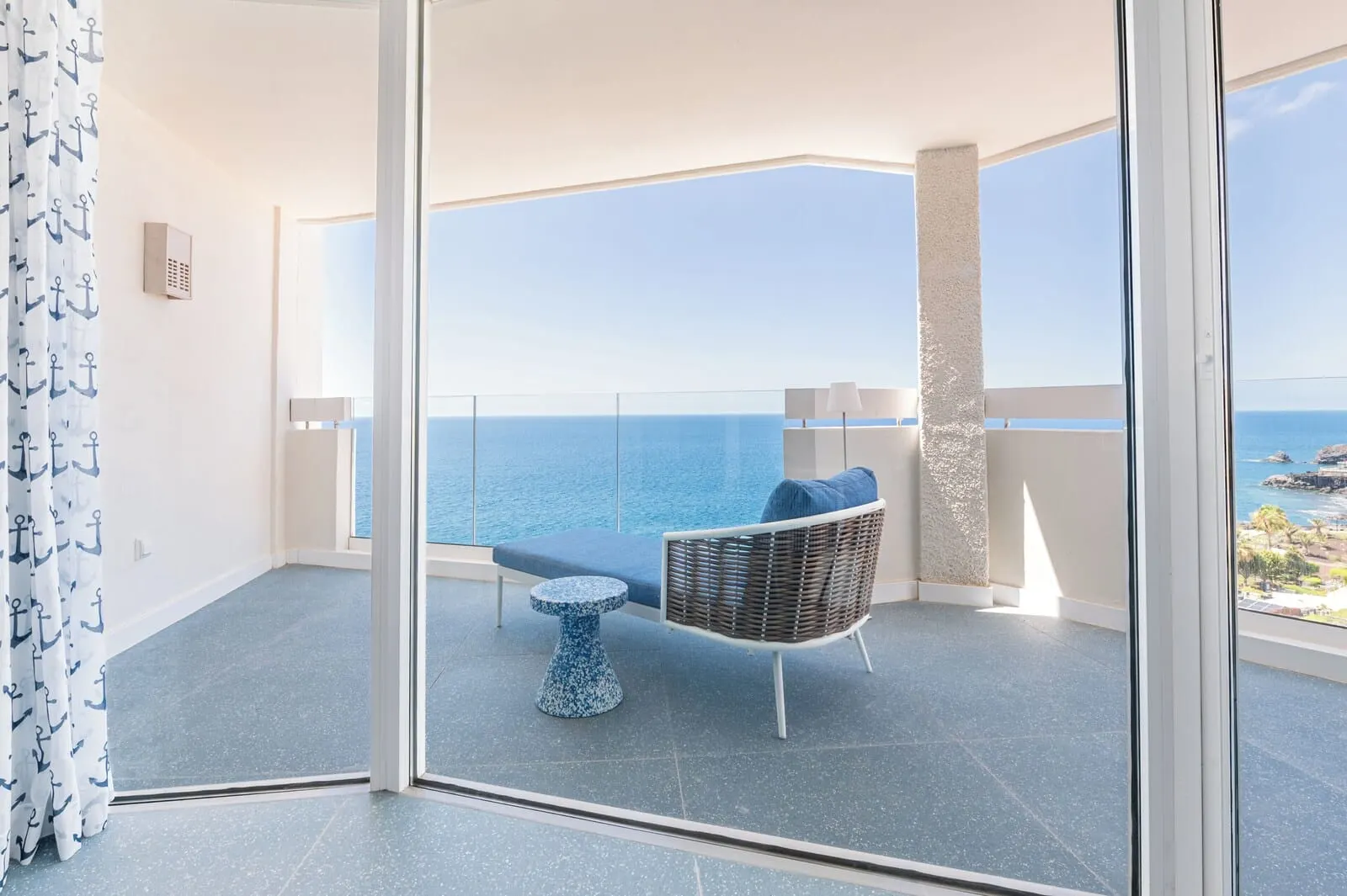 The Salmar: A balcony with a view of the sea, a wicker chair, a small round table