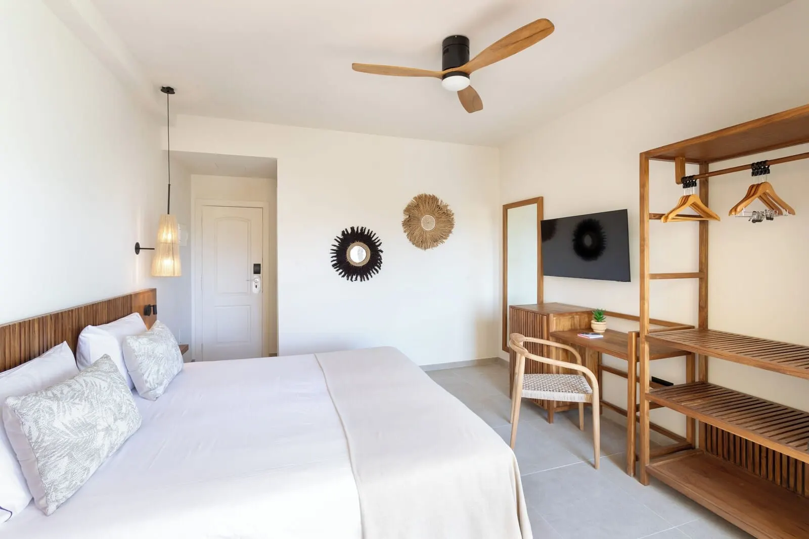 Playa Surf CBbC Hotel: A bedroom with a bed, a desk, a chair, a TV, and a ceiling fan