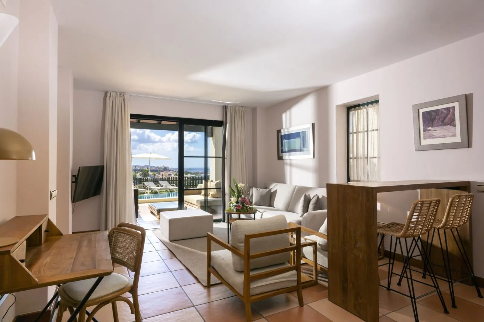 Hotel Suite Villa María: A modern living room with a sofa, chairs, a wooden table, and a TV