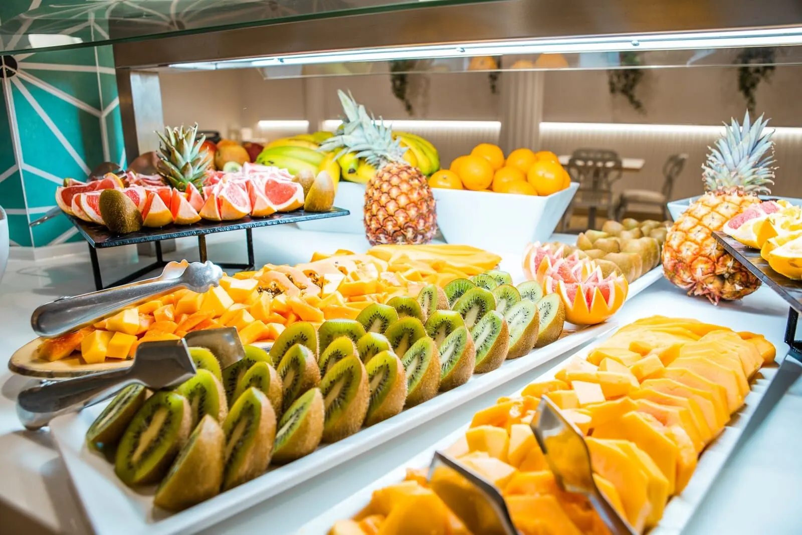 Checkin Bungalows Atlántida: A buffet with various fruits and vegetables, including sliced kiwi, mango, pineapple