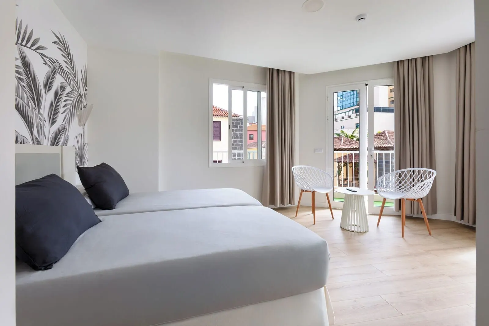 Hotel Boutique HC Maga: A modern hotel room with a bed, two chairs, a small table