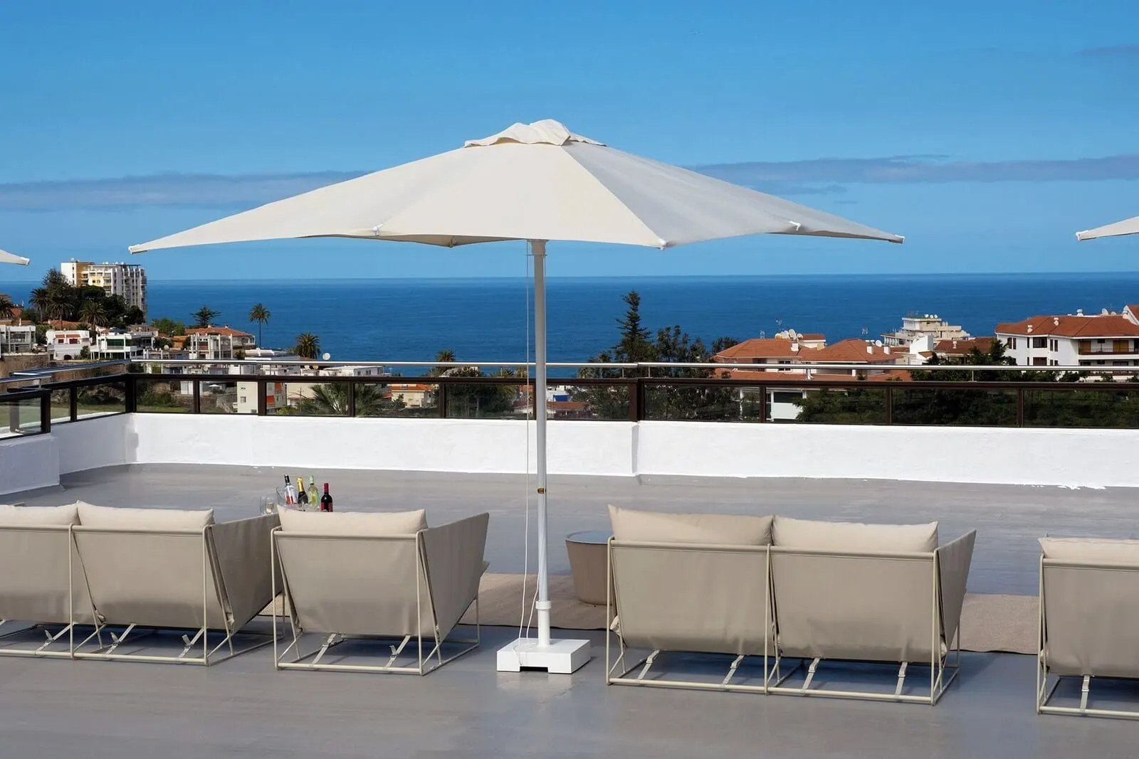 Muthu La Perla Tenerife: A rooftop terrace with a large white umbrella, beige lounge chairs