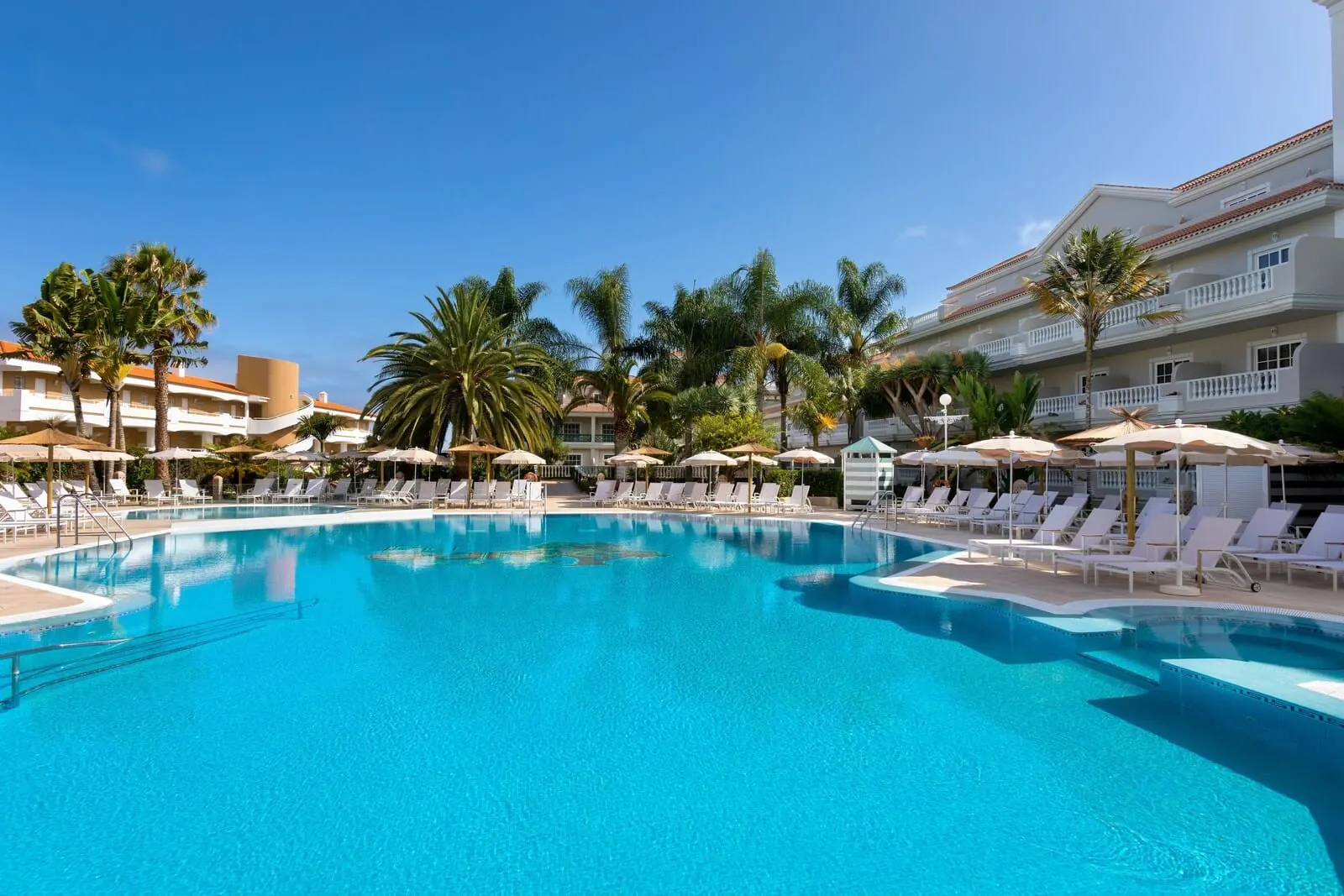 Hotel Riu Garoé: A large swimming pool with lounge chairs and umbrellas