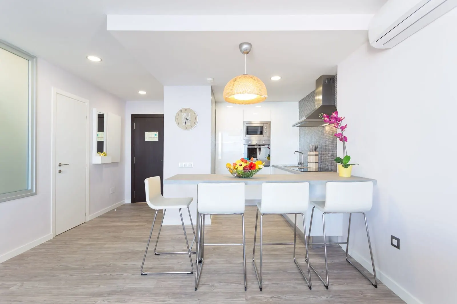 Royal Sun Resort: A modern kitchen with white cabinetry, a central island with bar stools