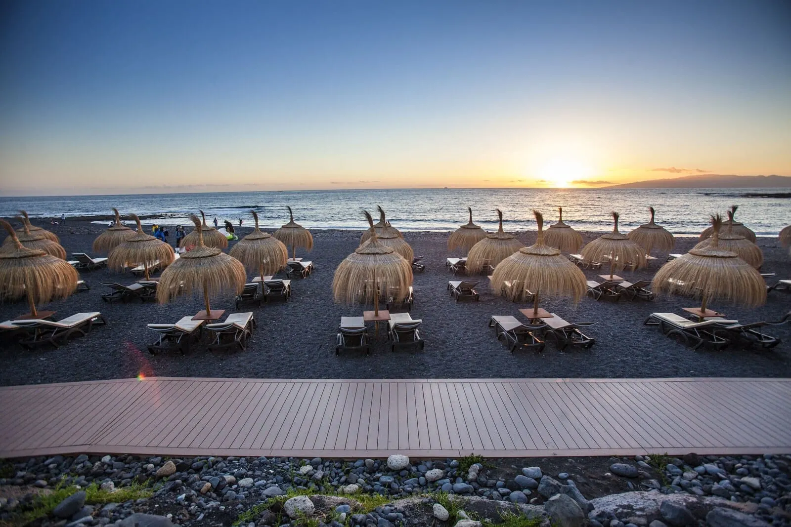 Royal Hideaway Corales Suites: A beachside restaurant with thatched umbrellas and wooden tables, overlooking the ocean