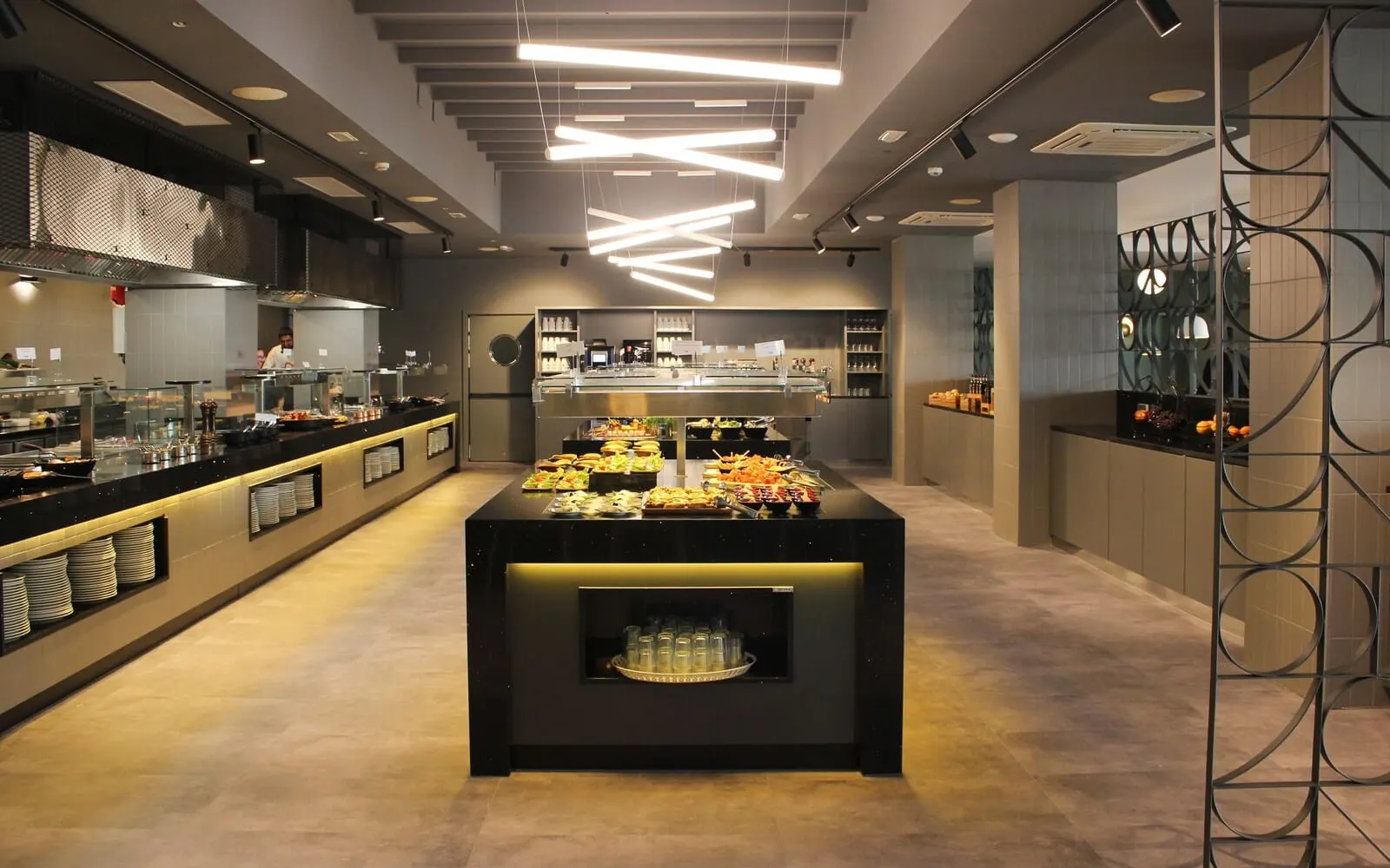 Coral Suites & Spa: A modern buffet setup with a variety of food items displayed on a central counter