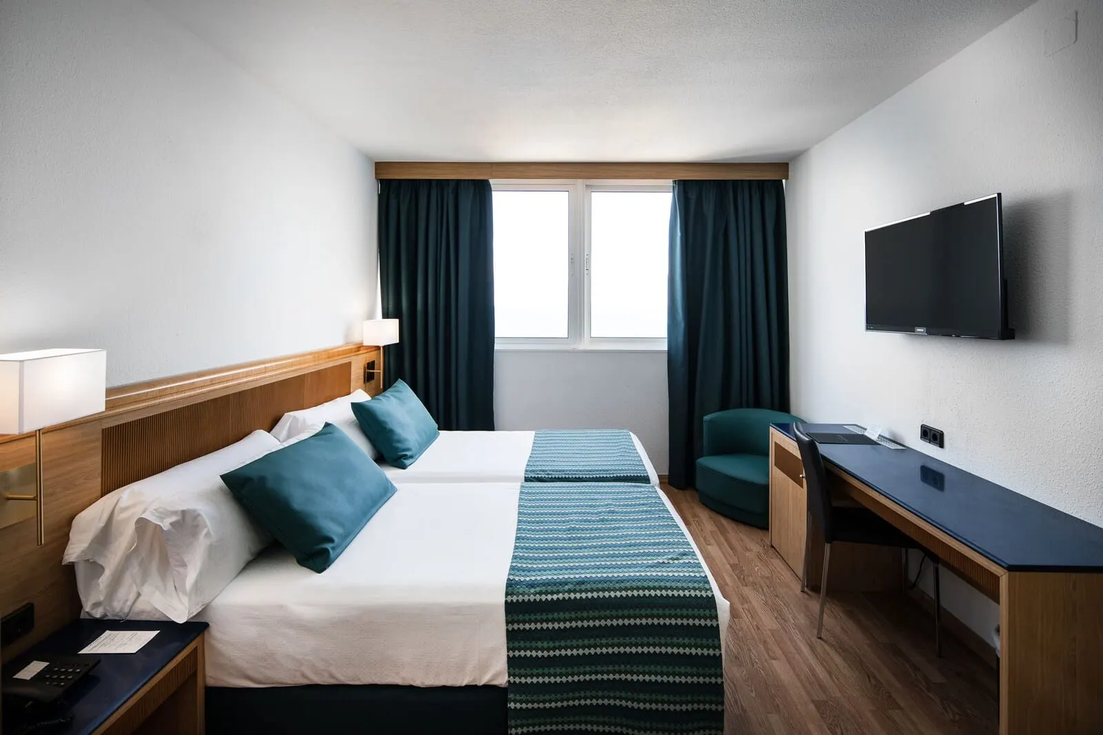 Catalonia Las Vegas: A hotel room with a bed, desk, and TV