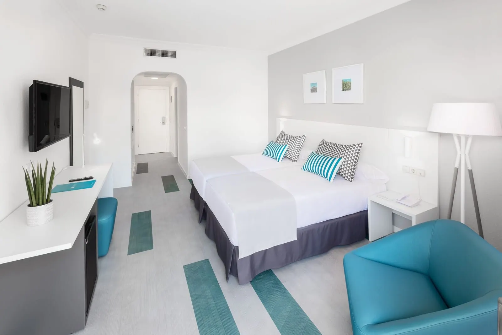BLUESEA Interpalace: A modern hotel room with a bed, desk, chair, and a TV