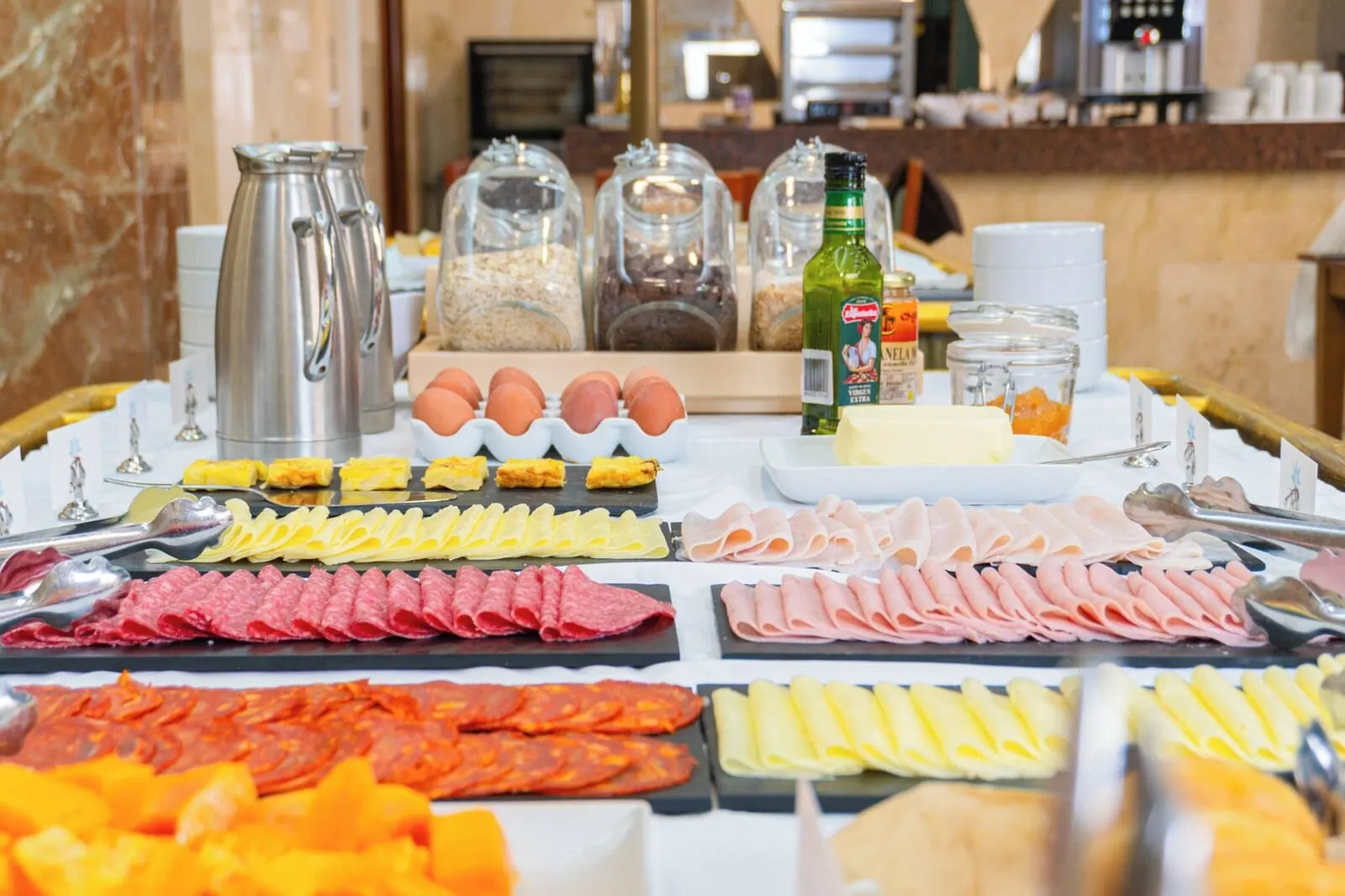 Hotel Aeropuerto Sur: A buffet with various food items including meats, cheeses, and eggs