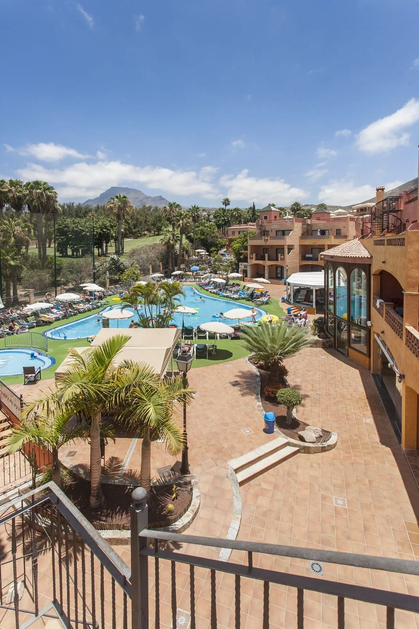 Villa Mandi Golf Resort: A resort with multiple swimming pools, palm trees, and a mountainous backdrop