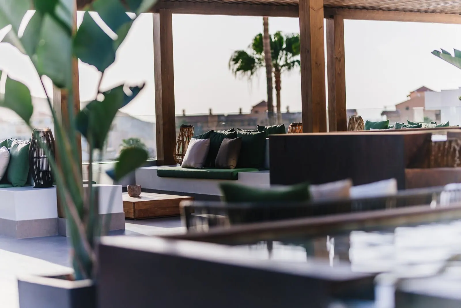Ohasis Boutique Suites: A modern outdoor seating area with a wooden pergola, cushioned seating