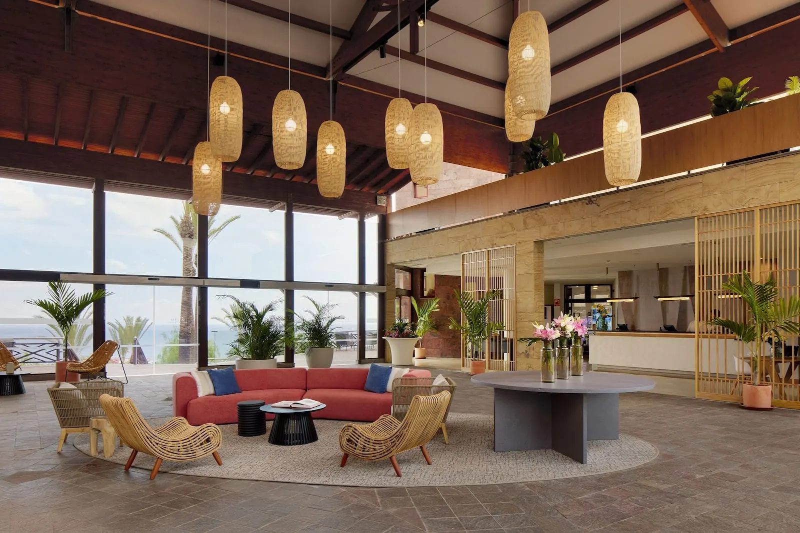 Meliá Jardines del Teide: A spacious lobby with a red sofa, wicker chairs, a round table