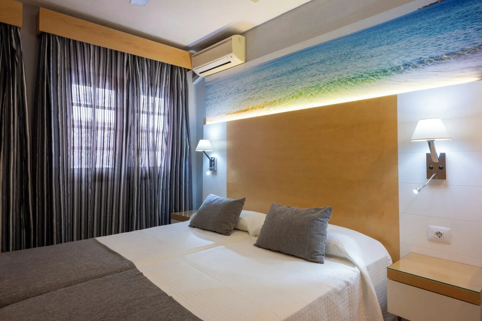 Ona Las Rosas: A hotel room with a bed, curtains, wall-mounted lamps, and a ceiling mural