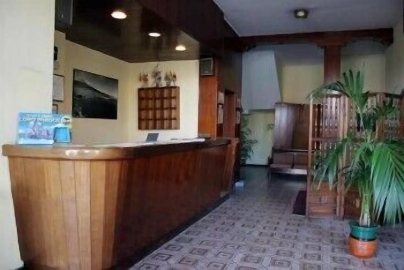 Hotel Tejuma: A reception area with a wooden counter, a framed picture on the wall