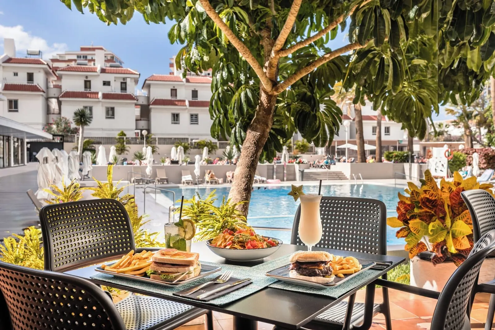 Catalonia Oro Negro: A dining table with a salad, burger, and fries