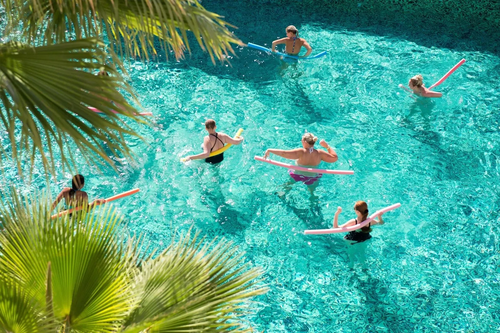 Marylanza Suites & Spa: A swimming pool with clear blue water, surrounded by palm trees