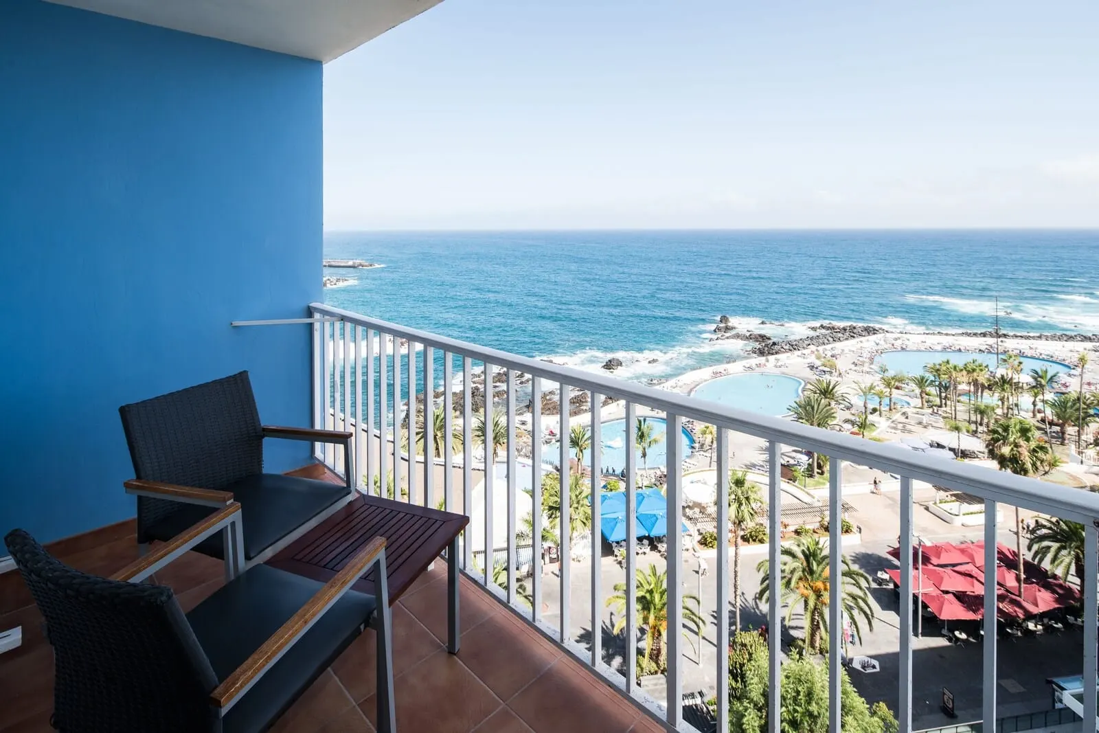 Catalonia Las Vegas: A balcony with a view of the ocean and a resort area including a pool and umbrellas