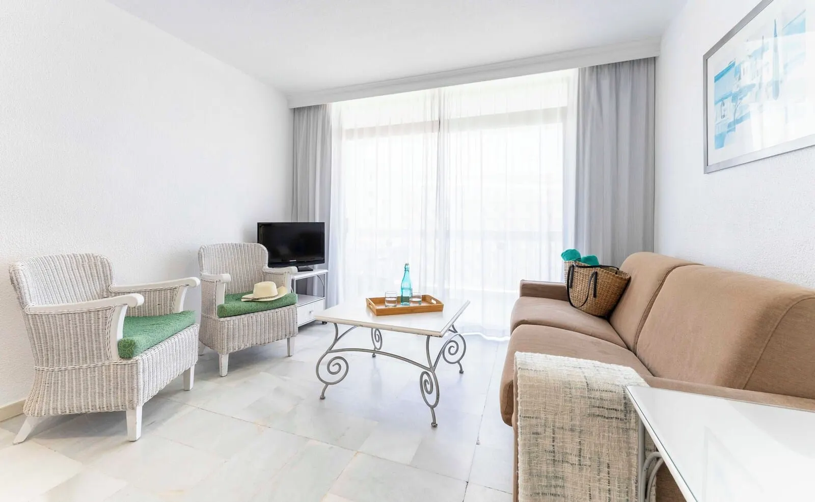 Ona Palm Beach: A living room with wicker furniture, a flat-screen TV, a coffee table, and a sofa