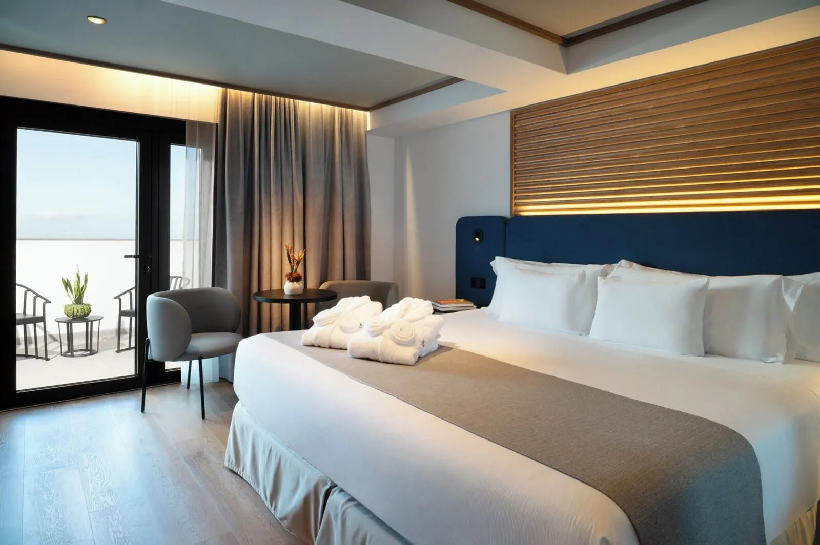 Barceló Santa Cruz Contemporáneo: A modern hotel room with a large bed, a seating area with chairs