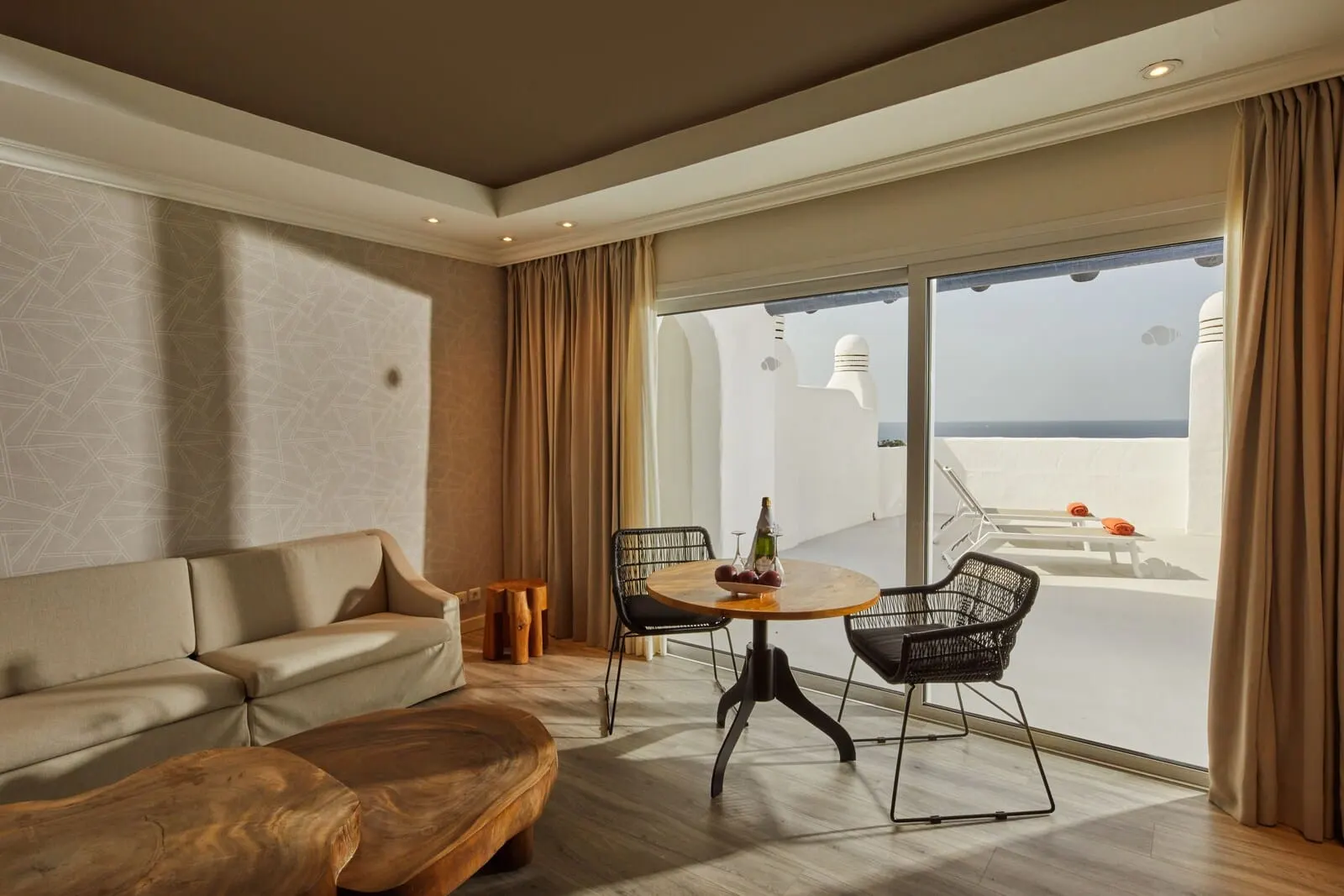 Hyatt Ziva Jardín Tropical Tenerife: A modern hotel room with a sofa, a wooden coffee table