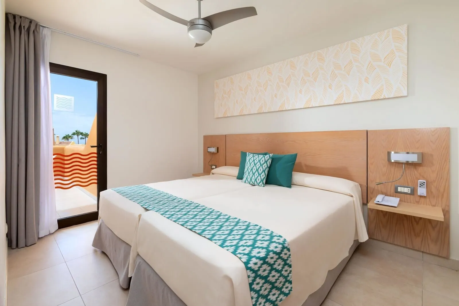Tagoro Family & Fun Costa Adeje: A hotel room with a bed, a ceiling fan, a wall-mounted phone