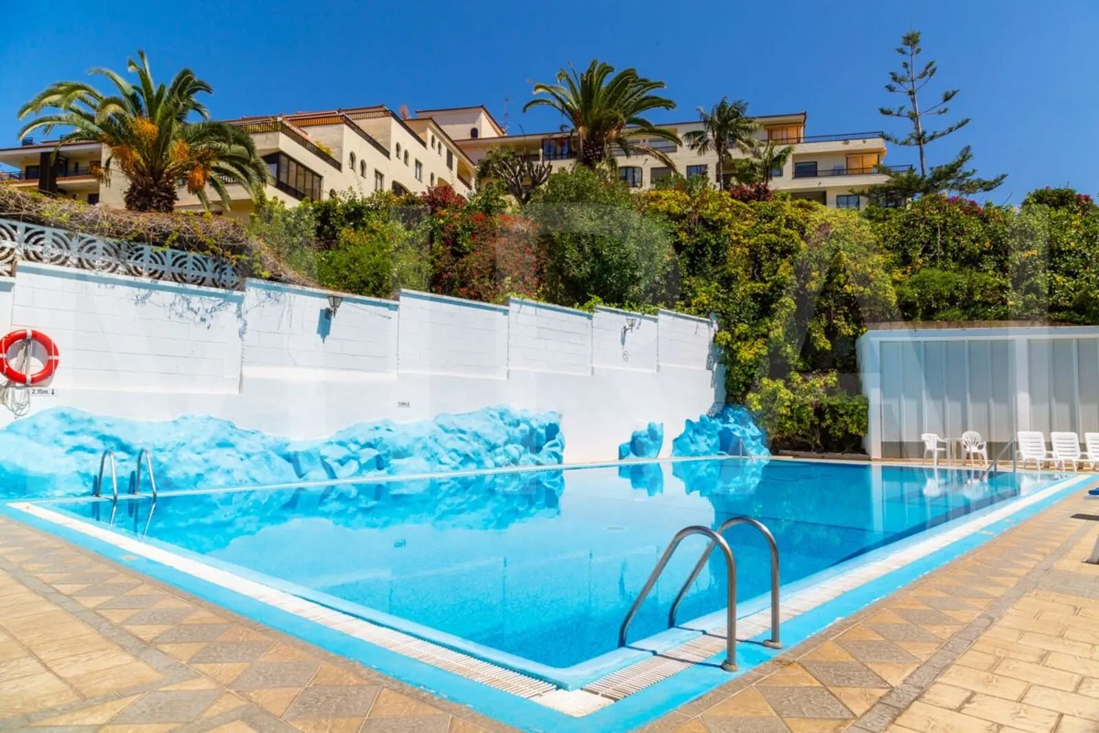 Apartamentos Pez Azul: A swimming pool with a clear blue water feature