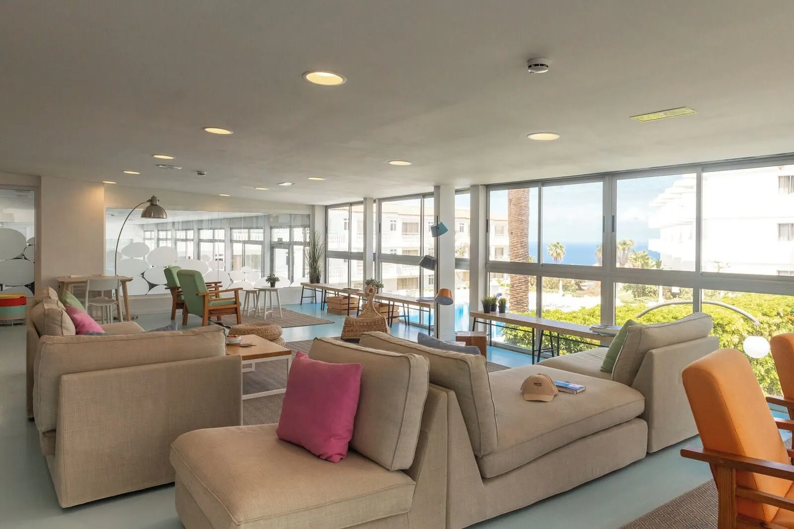 Route Active Hotel: A spacious living area with large windows, a pool, and a view of the ocean