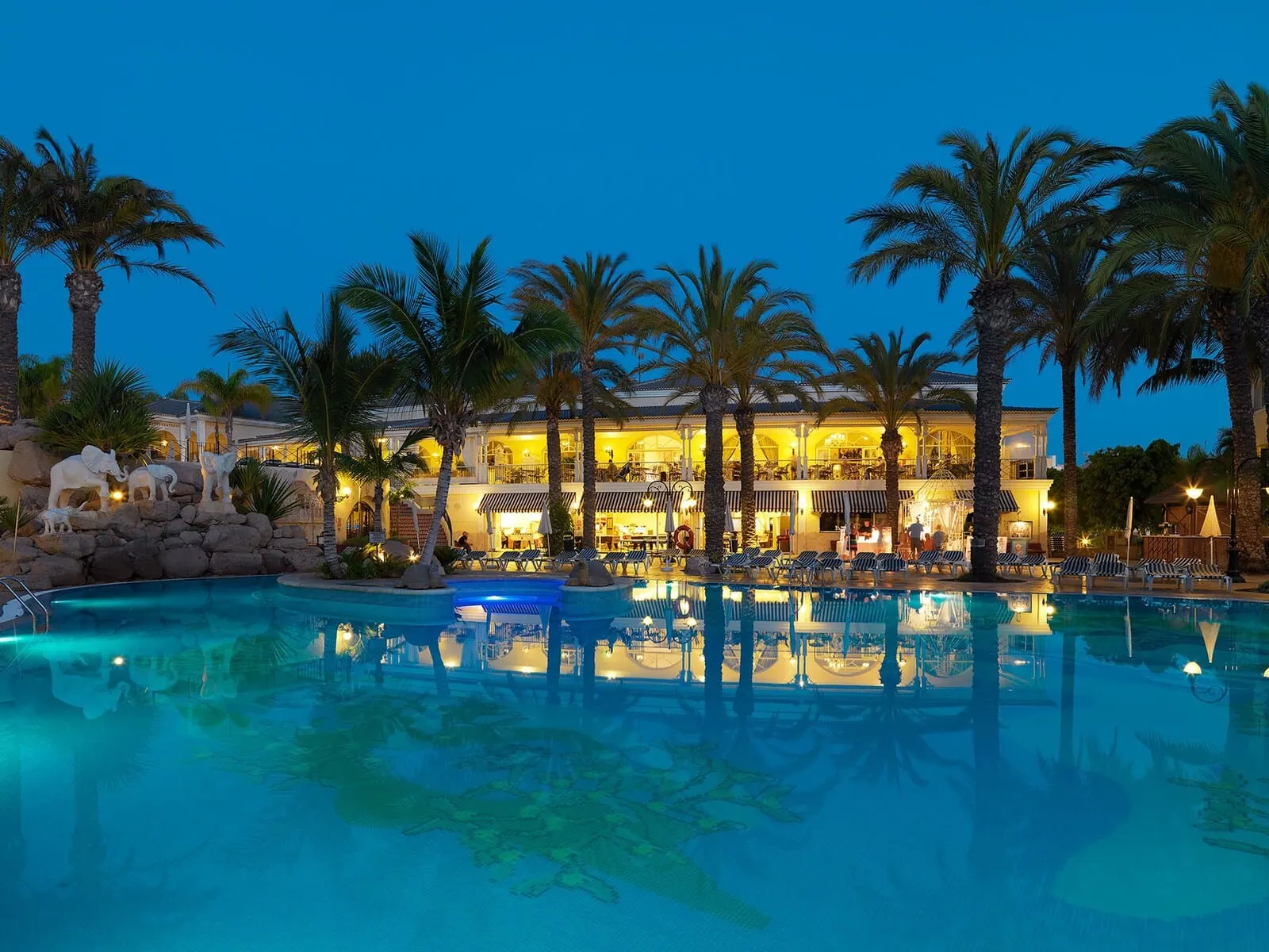 Gran Oasis Resort: A resort pool area with lounge chairs, palm trees