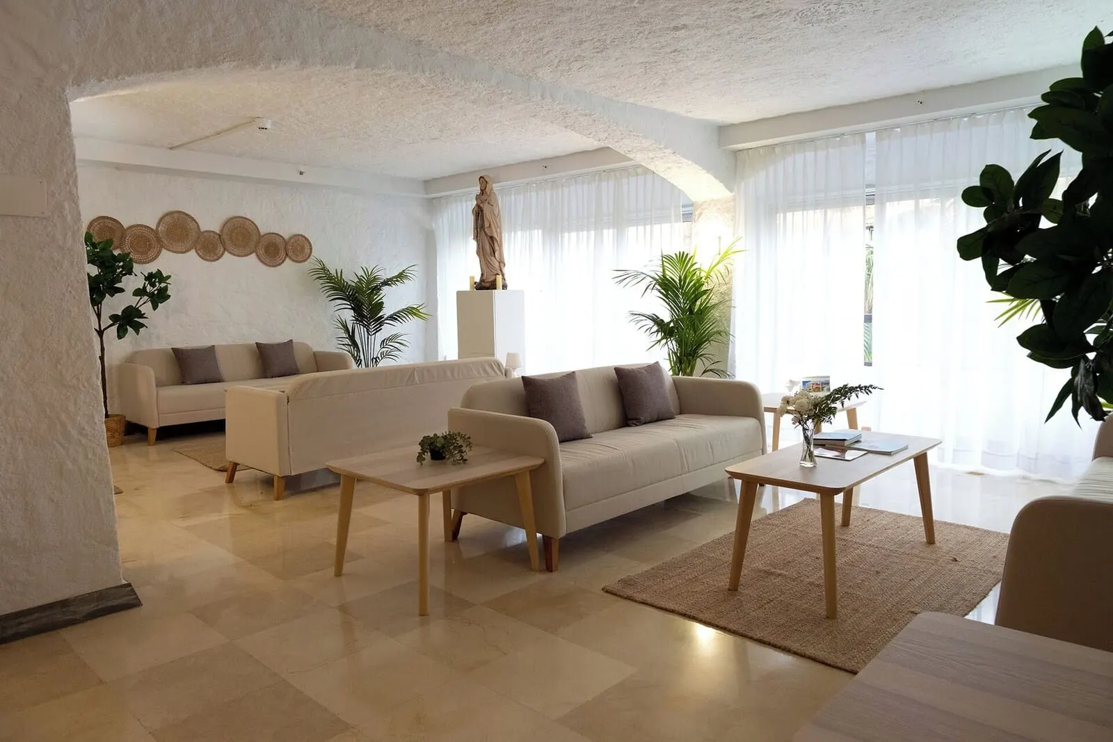 Muthu La Perla Tenerife: A spacious living room with a beige sofa, two coffee tables, and a large plant