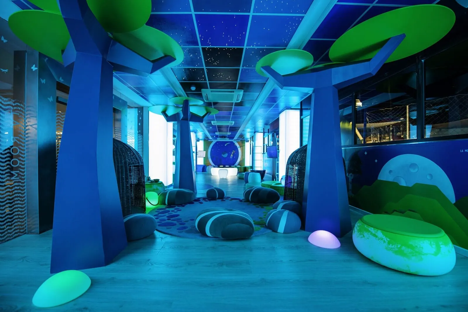 Spring Hotel Bitácora: A brightly lit indoor space with a starry ceiling, large green and blue bean bags