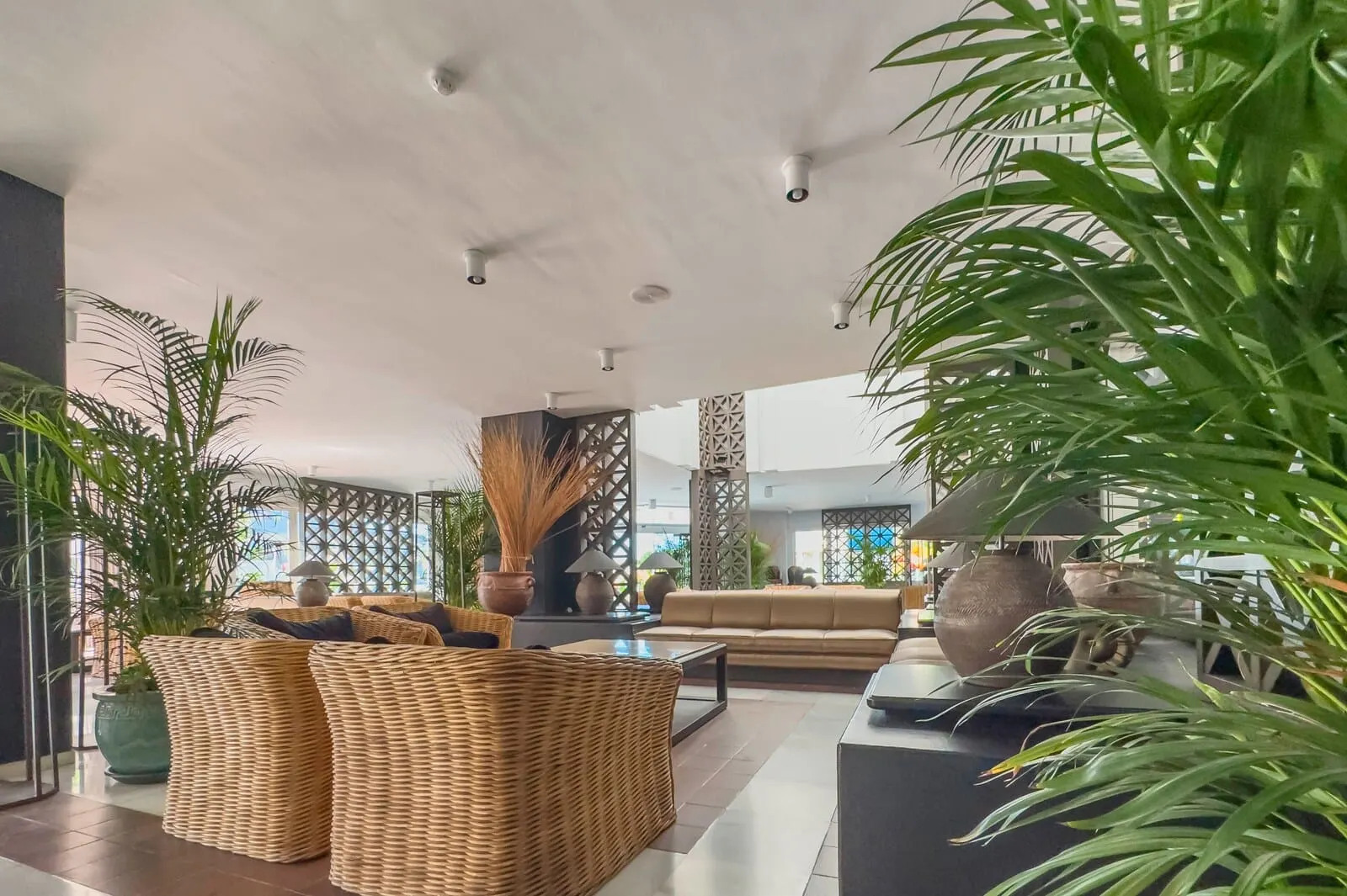 Apartamentos Parque del Sol: A spacious lobby with a high ceiling, wicker furniture, a large sofa