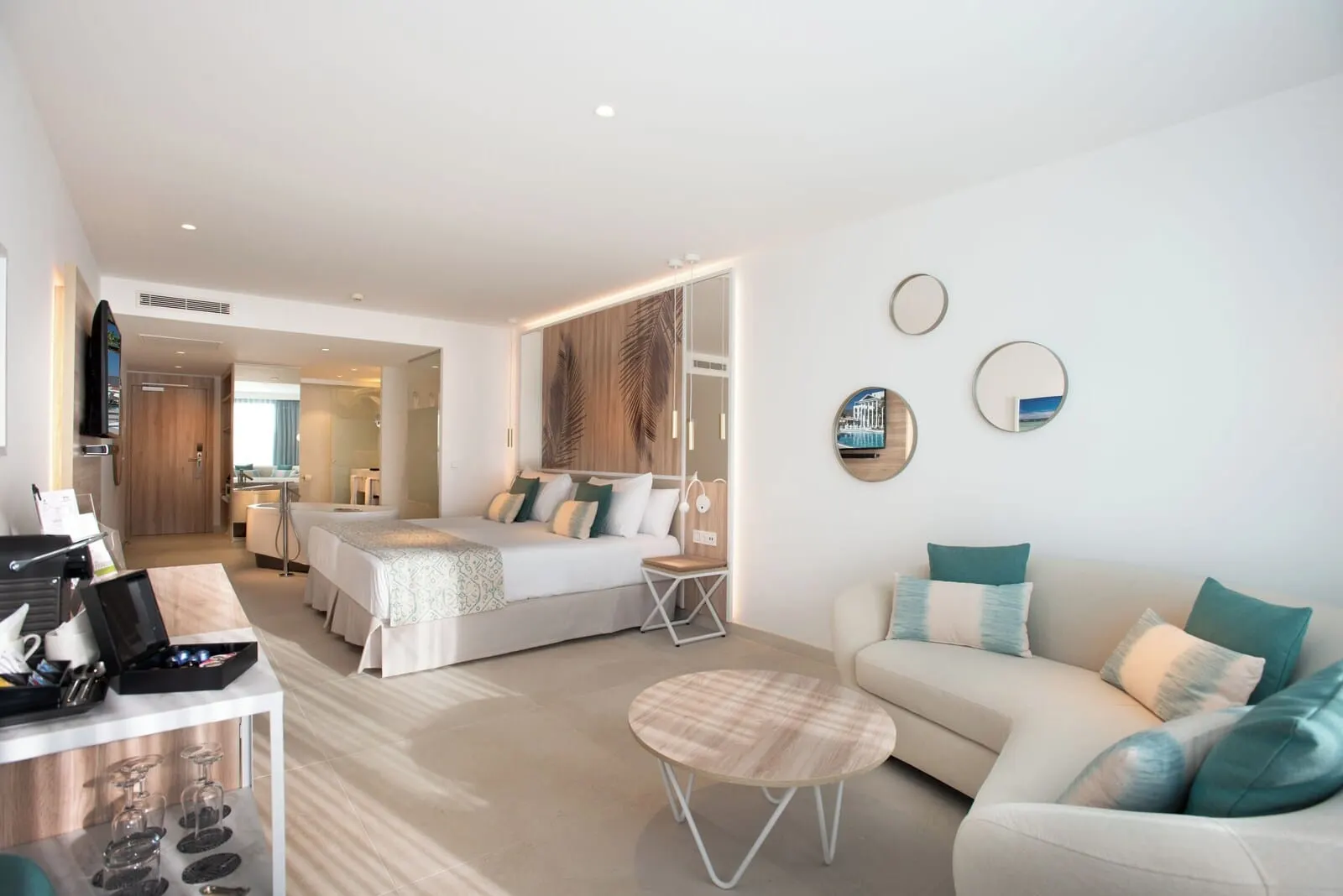 Guayarmina Princess: A modern hotel room with a bed, a sofa, a coffee table, and a TV