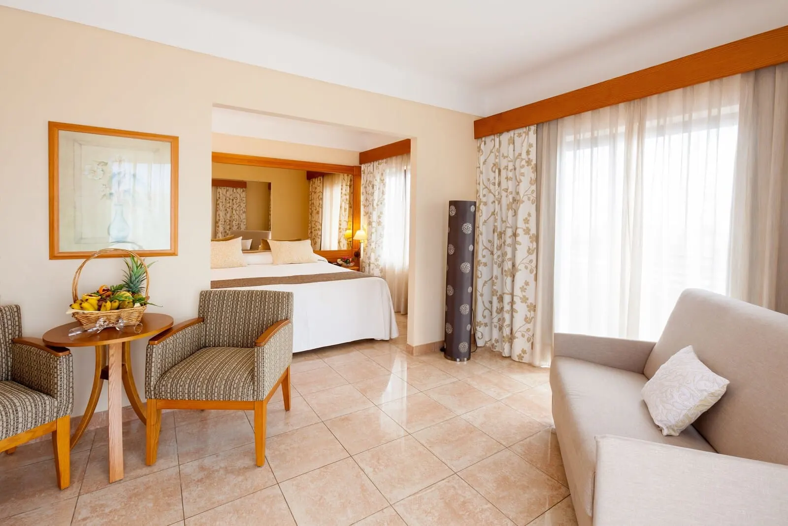 GF Fañabé: A hotel room with a bed, a sitting area with a table and chairs, and a sofa