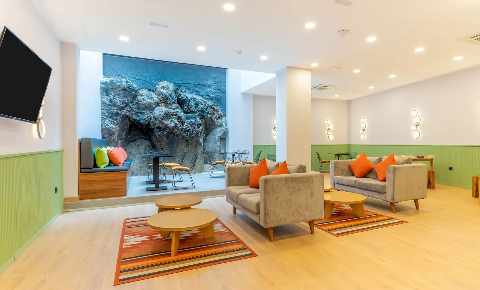 DWO Nopal: A modern living room with a large wall mural, comfortable seating, and a flat-screen TV