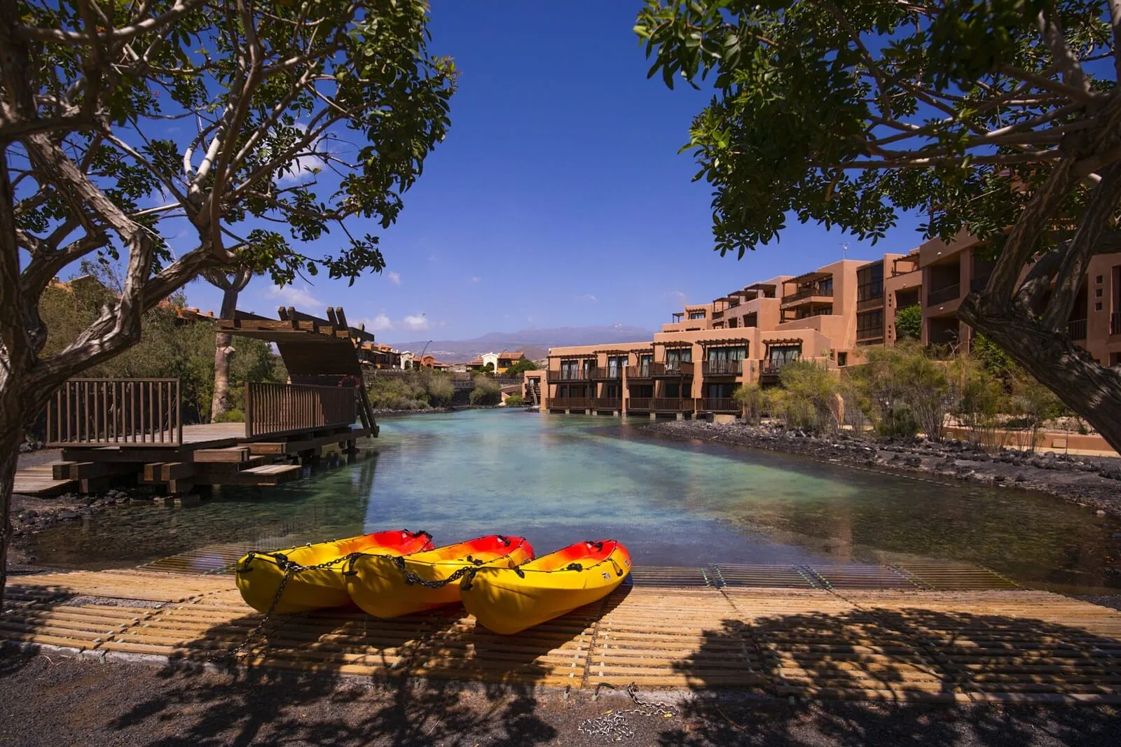 Barceló Tenerife: A river with kayaks, a wooden dock, and buildings in the background