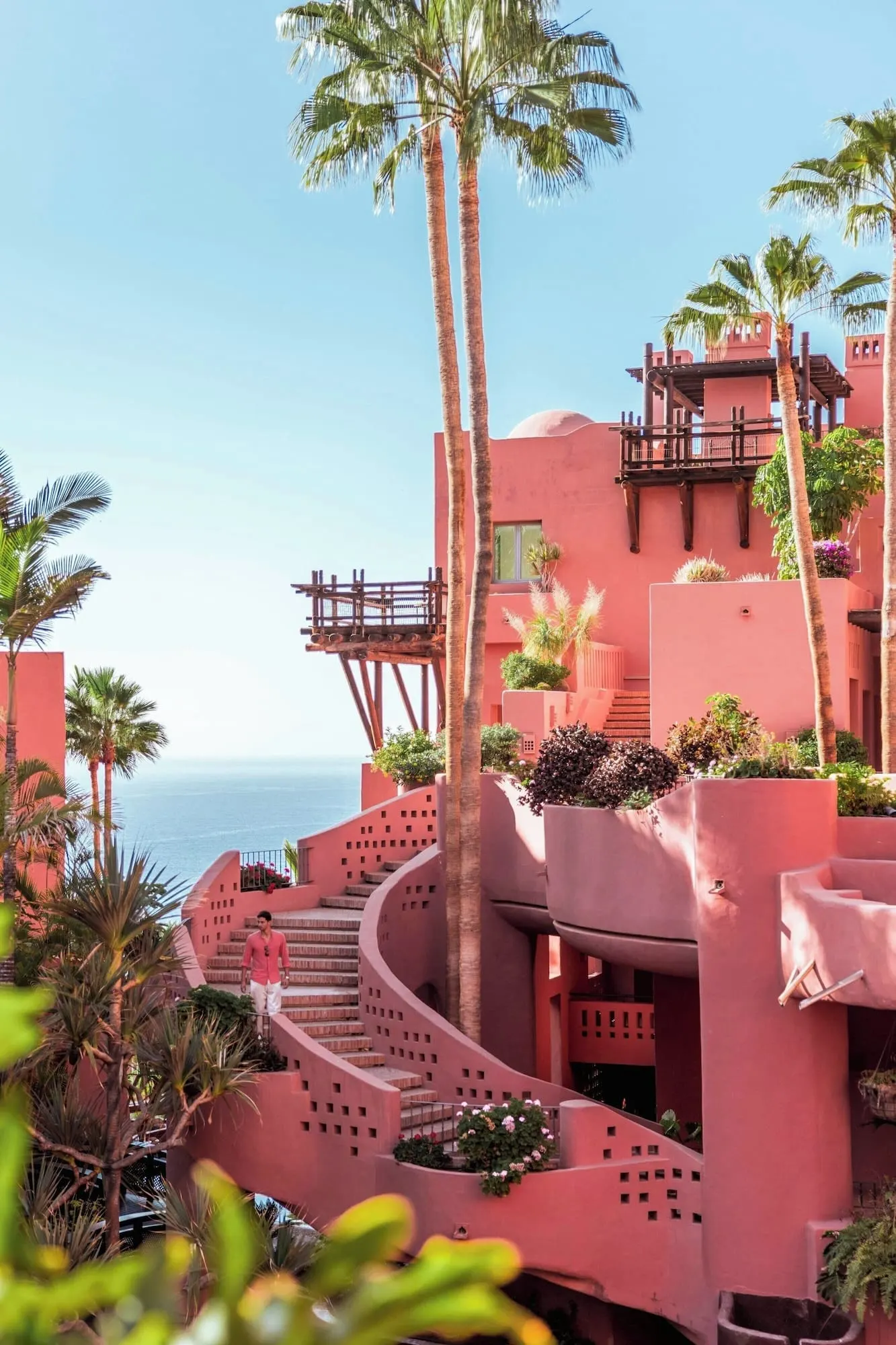 The Ritz-Carlton Tenerife, Abama: A pink building with a spiral staircase and palm trees