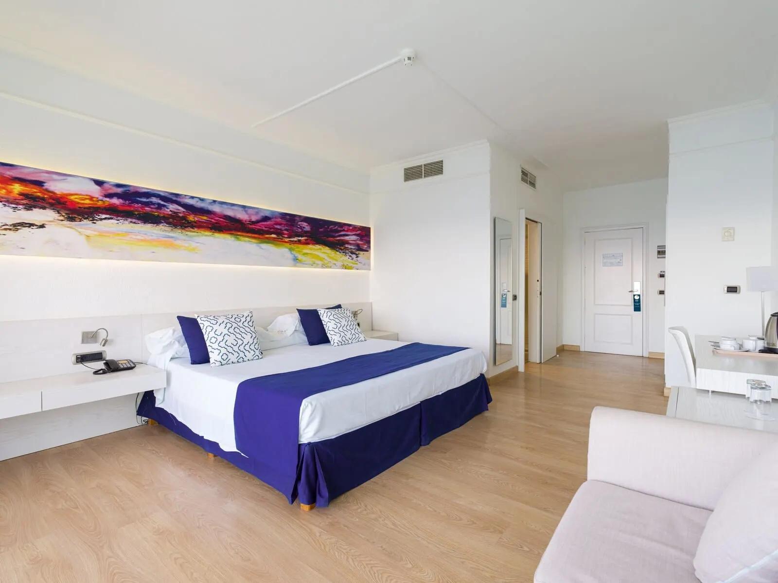 TUI Blue Los Gigantes: A modern hotel room with a large bed, a bedside table, a desk, and a chair